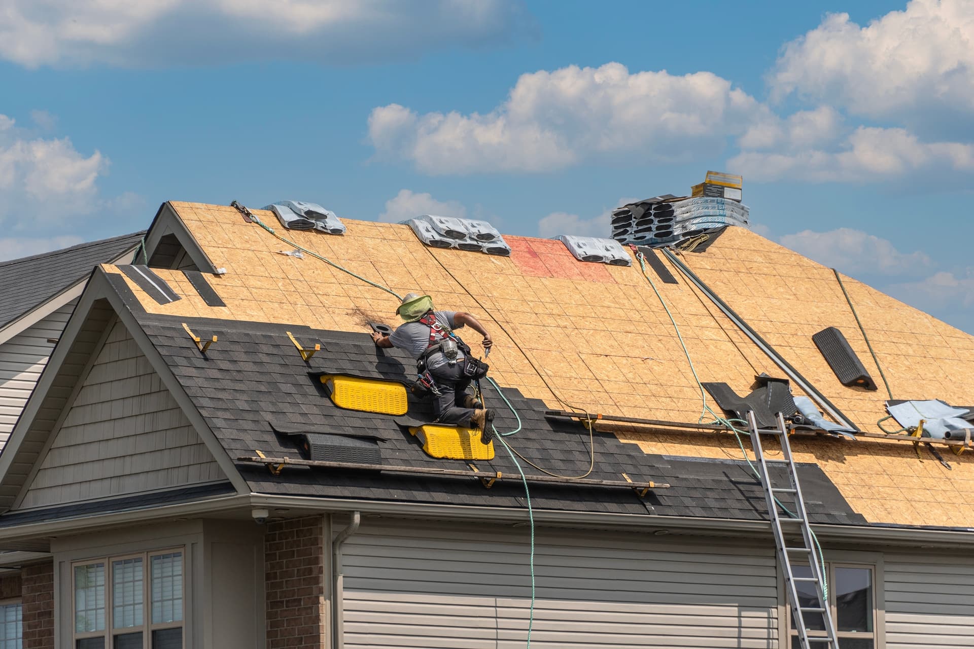 Roofer installing new shingles on a Canadian home