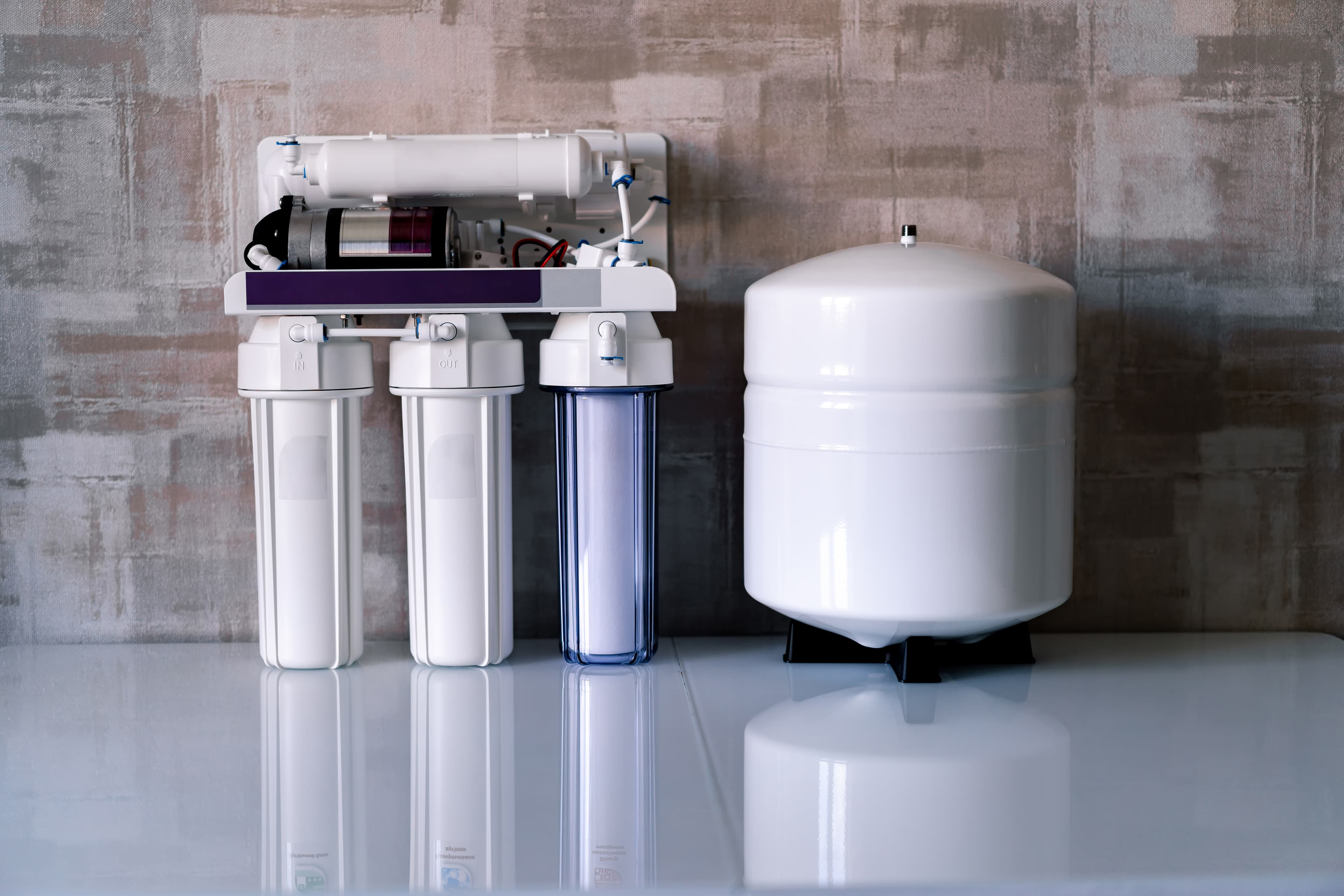 Reverse osmosis water filtration system with cartridges and tank.